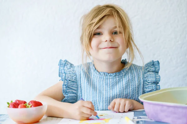 Preparation for school. Early education. Little girl is educated at home. Preschool child paint with different colorful pens and felt pencils