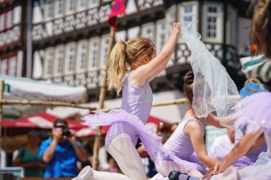 Küçük anaokulu kızı şehir festivalinde bale yapıyor. Güzel, mutlu balerin etekli çocuk balerin..