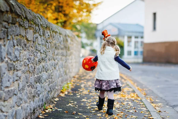 小孩子穿成巫婆的衣服 或者万圣节做菜 快乐的孩子在户外 带着橙色有趣的帽子和南瓜袋的甜蜜的困扰 十月的家庭节日期间 户外活动 — 图库照片