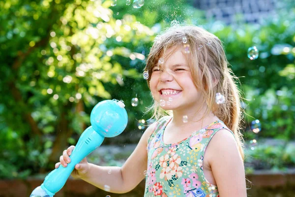 快乐的金发碧眼的学龄前小女孩与吹肥皂泡的乐趣 可爱的孩子在阳光灿烂的夏日玩耍 快乐活泼 健康的孩子 儿童活动 — 图库照片