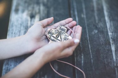 Kutsal onay ya da bildiri için elinde haç tutan kızın elleri