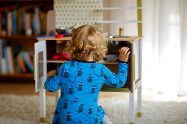 Sevimli küçük kız oyuncak mutfakla oynuyor mutlu sağlıklı bebek rol oyunlarıyla eğleniyor evde veya çocuk odasında çanak çömlek çaydanlığıyla oynuyor. Oyuncaklı aktif kız.