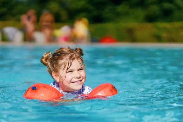 一个学龄前小女孩 穿着防护服 日落前在室外游泳池里玩耍 孩子们在外面的游泳池里学习游泳 在水里泼水 家庭假期 — 图库照片