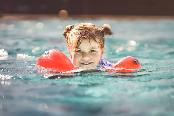 Mała Przedszkolanka Ochronnymi Pływakami Bawiąca Się Odkrytym Basenie Przed Zachodem — Zdjęcie stockowe