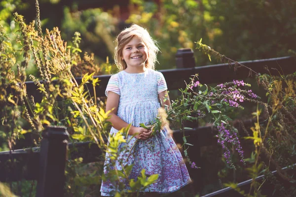 屋外で野生の花を持つかわいい就学前の女の子の肖像画 晴れた夏の夜の幸せな面白い子供 — ストック写真