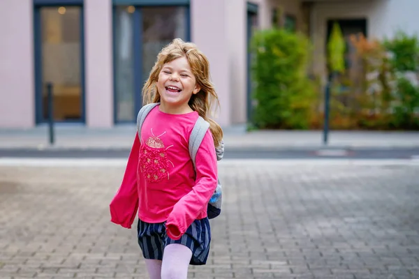 Cute little preschool girl o the way to school Healthy happy child walking to nursery school and kindergarten. Smiling child with backpack on the city street, outdoors. Back to school