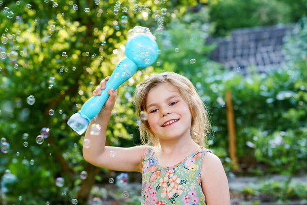 ソープバブルブロワーを吹いて楽しんでいる幸せな小さなブロンドの就学前の女の子 晴れた夏の日に遊ぶかわいい子供 健康な子供を幸せに 子供のための活動 — ストック写真
