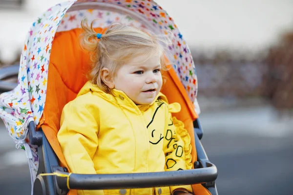 一个可爱的小女孩坐在婴儿车或婴儿车里散步的画像 快乐可爱的孩子在户外玩的开心 健康的女儿城市的街道交通 — 图库照片
