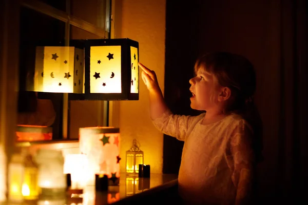 小女孩坐在窗边 手里拿着自制的灯笼和蜡烛 为圣马丁游行 蹒跚学步的孩子看着闪闪发光的灯笼 德国传统Martinsumzug 家庭装修 — 图库照片