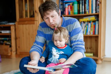 Kafkasyalı bir babanın portresi. Küçük kızıyla birlikte kitap okuyor. Ev okulunda öğretmenden, eğitimden mutlu aile sevgisi, uyku zamanı hikaye babaları günü konsepti..