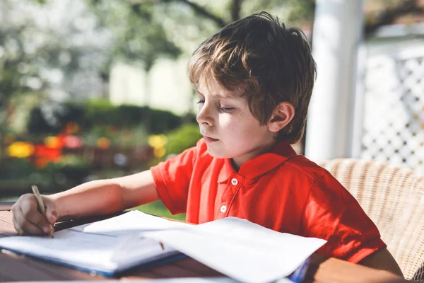 宿題を作る家で小さな子供の少年の肖像画 カラフルなペンで手紙を書く 小さな子供が屋内で運動をしている 小学校と教育 家庭教育の概念 — ストック写真