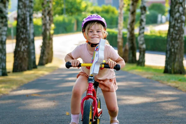 带着头盔的学龄前小女孩骑着平衡自行车跑步 快乐的孩子驾驶 骑自行车 户外活动 儿童暑期活动 — 图库照片