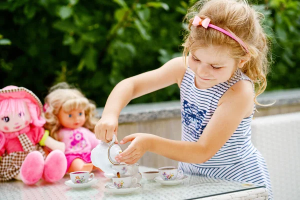 小さな未就学児の女の子が人形で遊んでいる おもちゃでお茶パーティーをお楽しみください 子供のためのロールゲーム 一人のための活動 小さな子供のためのロールゲーム — ストック写真