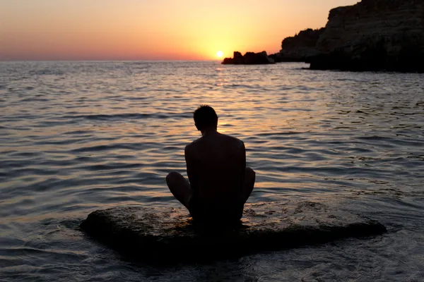 Homme méditant au coucher du soleil — Photo