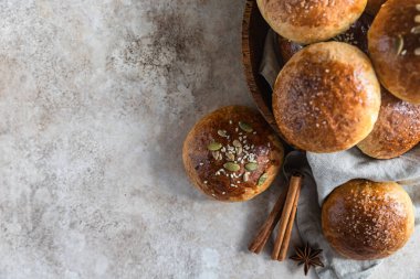 Tarçın ve anason kaplı balkabaklı çörekler, açık beton arka plan. Üst görünüm.