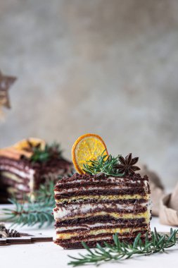 Biberiye, baharat ve kurutulmuş portakal dilimleriyle süslenmiş çikolata katmanlı pasta. Kutlama Noel 'i ya da yeni yıl dekorasyonu. Rus ballı keki, Medovik..