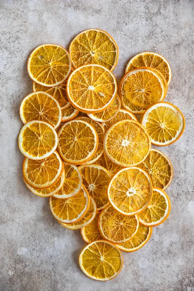 Natural dried oranges on light concrete background. Sliced and dried citrus fruit. Top view. — Stock Photo, Image