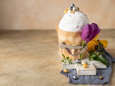 Geleneksel Ortodoks tatlı ekmeğiyle Paskalya kompozisyonu. Kulich krema, şeker şeklinde yumurta ve lale ile süslenmiş. Boşluğu kopyala.