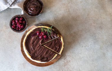 Çikolata ganache, kiraz ve beton kaplama biberiyeli klasik kremalı peynirli kek. Popüler şenlikli tatlı. Üst görünüm.