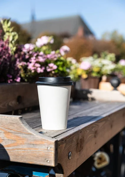 Einweg-Pappbecher mit Kaffee den Hintergrund der Stadt. Trinken zum Mitnehmen. Leerer Raum für Text, Attrappe. — Stockfoto