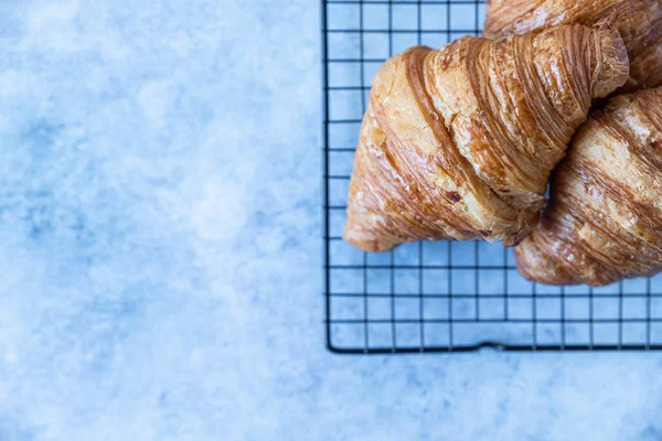 Lezzetli çıtır kruvasanlar, mavi beton arka plan. Kahvaltı için fırın. Üst Manzara. Boşluğu kopyala.
