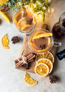 Sonbahar ya da kış çayı ya da portakallı punç ve cam bardaktaki baharatlar. Sıcak baharatlı içecek. Mevsimlik sıcak içecek. Üst görünüm.