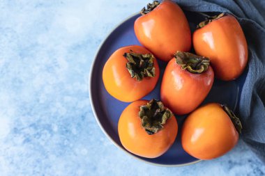 Mavi beton arka planda taze organik olgun hurma. Üst görünüm.