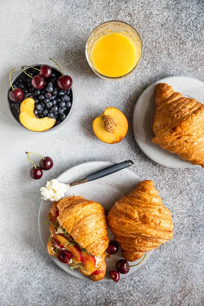 Sandwiches de croissant con nectarina, cereza y ricotta o queso crema en un plato con zumo de naranja para un sabroso desayuno. Vista superior. — Foto de Stock