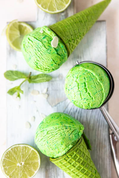 Homemade green ice cream with lime and mint in green waffle cone. Summer dessert. Top view. Selective focus.