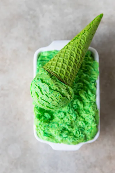 Homemade green ice cream with lime and mint in green waffle cone. Summer dessert. Top view. Selective focus.
