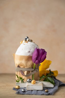 Geleneksel Ortodoks tatlı ekmeğiyle Paskalya kompozisyonu. Kulich krema, şeker şekilli yumurta ve lale ile süslenmiş..