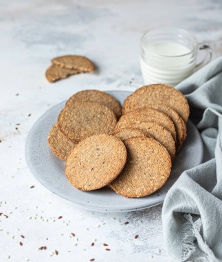 Lezzetli kraker ve bir fincan süt. Gri taş arka planda atıştırmalık ya da kahvaltı.