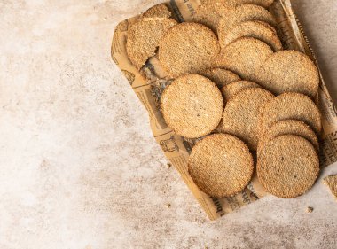 Kahverengi arka planda susamlı ve keten tohumlu leziz krakerler. Sağlıklı atıştırmalıklar. Üst görünüm.