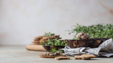 Ev yapımı et ya da ciğer ezmeli çoklu tahıllı kraker ve mikro yeşil, beton arka plan.