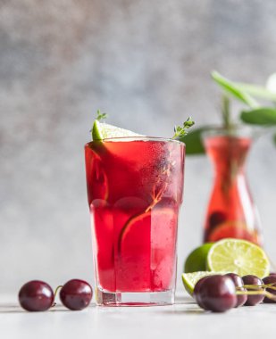 Limonata ya da alkolsüz, kiraz ve limonlu, gri beton arka planda. Yaz içeceği..
