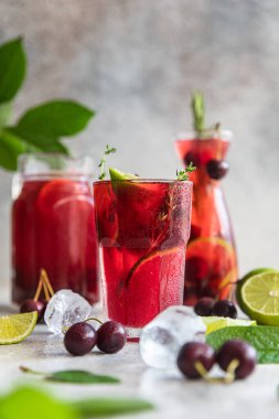 Kokteyl ya da kiraz ve limonlu limonata, gri taş arka plan. Mocktail. Soğuk yaz içeceği.