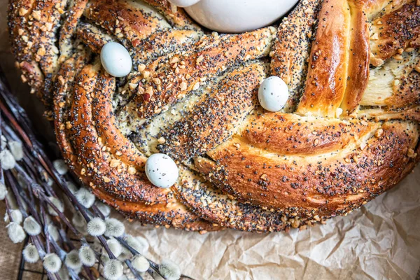 Easter twist bread with poppy seed and nut filling decorated with willow twigs and Easter eggs. Homemade babka or brioche bread. — Stock Photo, Image