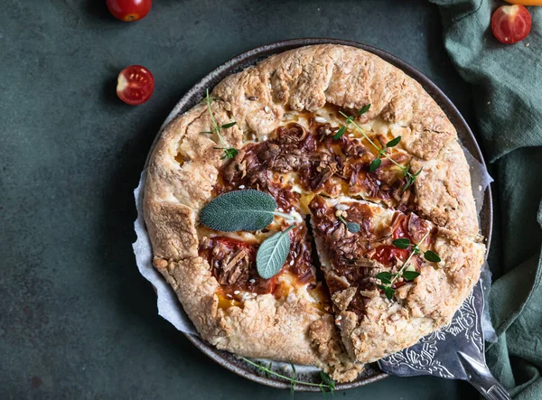 Lezzetli domates turtası, açık turta ya da domatesli galet ve aromatik otlarla süslenmiş peynir. Üst görünüm.
