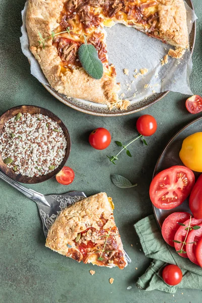 Lezzetli domates turtası, açık turta ya da domatesli galet ve aromatik otlarla süslenmiş peynir. Üst görünüm.