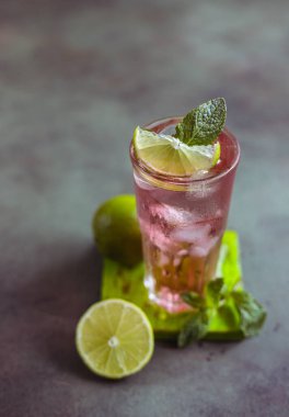 Taze pembe kokteyl ya da limonlu mocktail içeceği, pembe greyfurt suyu ve nane, yeşil arka plan. Paloma.