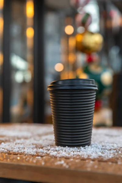 Takeaway disposable cup for hot drink on wooden table. Street walk cafe. Coffee, tea or mulled wine to go. Empty space for text, mockup. — Stockfoto