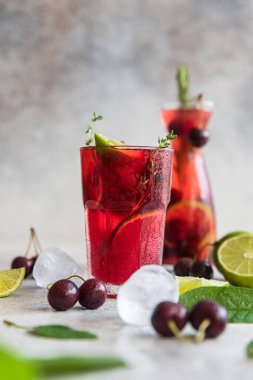 Kokteyl ya da kiraz ve limonlu limonata, gri taş arka plan. Mocktail. Soğuk yaz içkisi. Seçici odak.