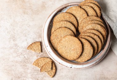 Kahverengi arka planda susamlı ve keten tohumlu leziz krakerler. Sağlıklı atıştırmalıklar. Seçici odaklanma. Üst görünüm.
