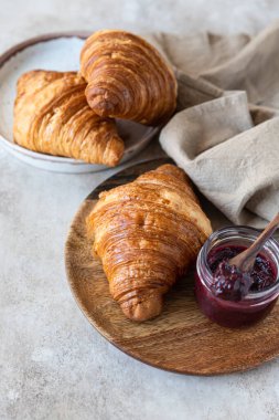 Reçelli taze kruvasan ve beton kaplama. Lezzetli kahvaltı için ev yapımı fırın. Seçici odak.