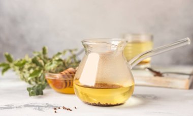 Karabuğday çayı ve ballı granüller, açık gri beton arka plan. Sağlıklı karabuğday çayı, Ku Qiao tohumları. Sağlıklı yemek..