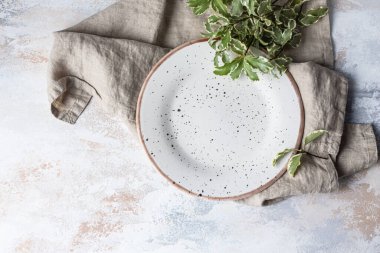 Açık arkaplanda yeşil yapraklı boş bir araç plakası. Bahar şatafatlı sofra, restoran menüsü konsepti. Yemek yerleştirme için maket. Şen minimalist konsept. Düz yat, boşluğu kopyala