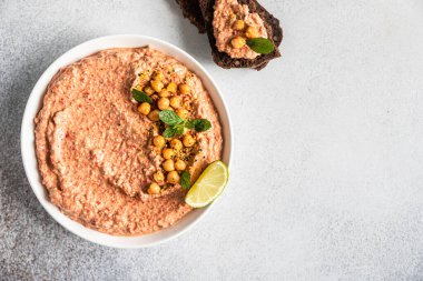 Nane ve limonla kavrulmuş kırmızı biberli humus garnitürü. Kırmızı dolma biber, limon ve naneli nohut püresi. Vejetaryen atıştırması.