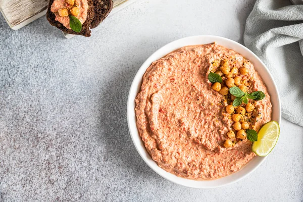 Gebratener roter Paprika Hummus garniert mit Minze und Limette. Kichererbsenpüree mit rotem Paprika, Limette und Minze. Vegetarischer Imbiss. — Stockfoto
