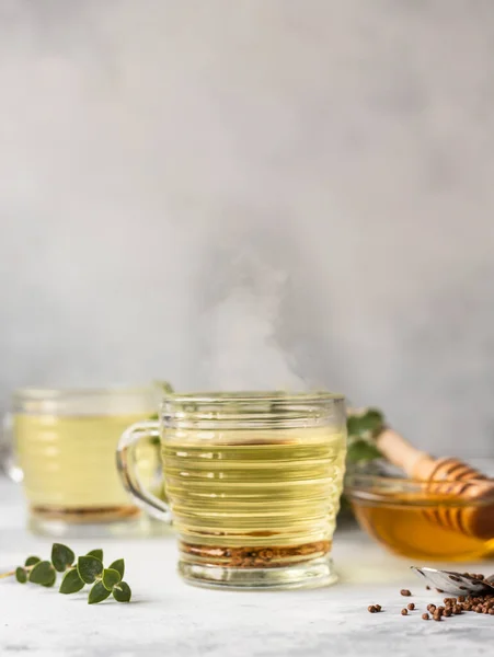 Kupa hajdina tea, granulátum és méz, szürke beton háttér. Superfood Tajvan Ku Qiao hajdina tea és búzadara. Méregtelenítő és egészséges élelmiszerek. — Stock Fotó