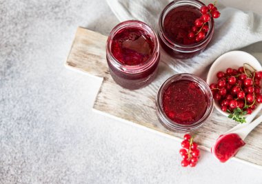 Ev yapımı frenk üzümü reçeli veya cam kavanozlarda reçel ve ahşap tahtada taze üzümler. Üst görünüm.